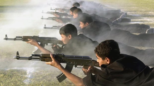 Iraqi youth practice firing AK-47 assault rifles at a summer military camp in Baghdad in 2002.  A Melbourne court has been told that Sanar Ghanim learned the art of war in Iraq as a boy before coming to Australia when he was 14. 