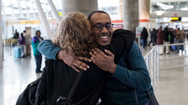 Dr. Kamal Fadlalla, who was stranded in his native Sudan, embraces Anita Eliot, an attorney, in John F. Kennedy International Airport. 