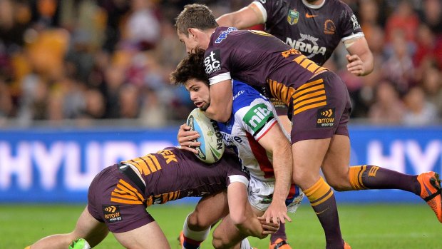 Going nowhere: Jake Mamo of the Knights is wrapped up by the Broncos. 