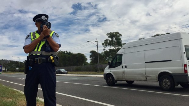 An ACT policing sergeant from Road Safety Operations checks drivers speeds on Barry Drive.