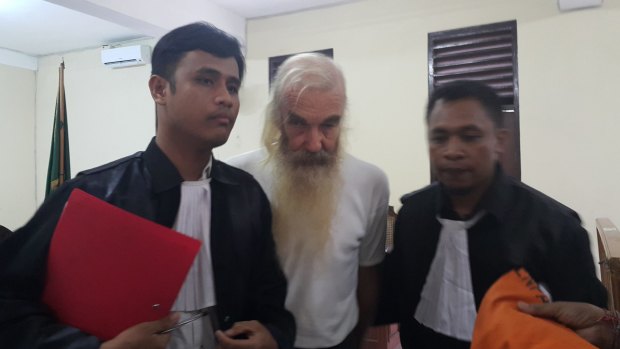 Robert Andrew Fiddes Ellis flanked by his lawyers Benny Hariyono (left) and Yanuar Nahak (right).
