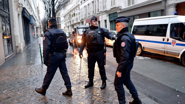 Police stand guard outside the offices of French daily newspaper Liberation as the remaining members of the Charlie Hebdo editorial staff arrive for a meeting. 