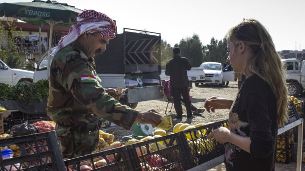 A Kurdish soldier buys fruit at the local markets in northern Iraq.