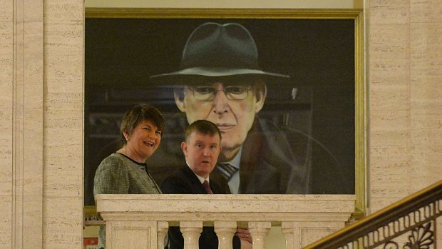 Democratic Unionist Party leader Arlene Foster (L) walks past a painting of Ian Paisley at Stormont on January 11, 2016.