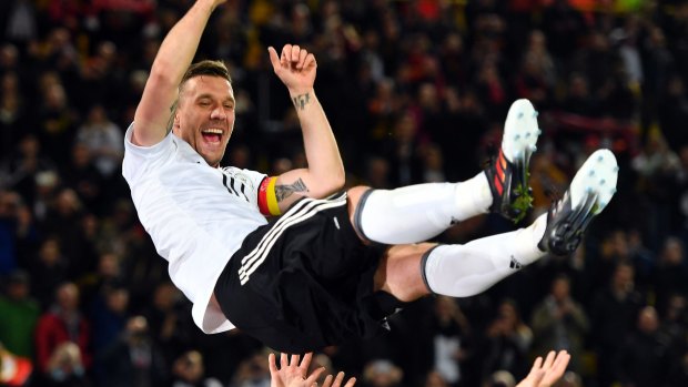 Germany's Lukas Podolski is thrown up in the air by his teammates after the friendly in Dortmund.