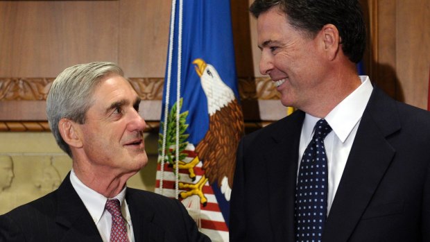 Then-incoming FBI director James Comey, right, talks with outgoing FBI director Robert Mueller before Comey was officially sworn in in 2013.