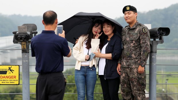 Visitors pose for a photograph with a South Korean soldier at the Imjingak pavilion near the Demilitarised Zone in Paju, South Korea.