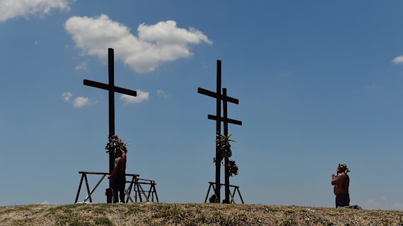 Atonning for his sins, a man prays in front of the crosses that will be used in the Passion Play.
