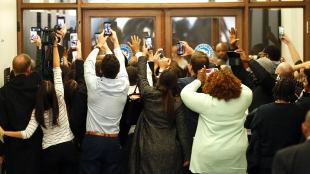 People rush the doors of the jury assembly room as former president Barack Obama departs after being dismissed from jury duty in the Daley Centrer on Wednesday.