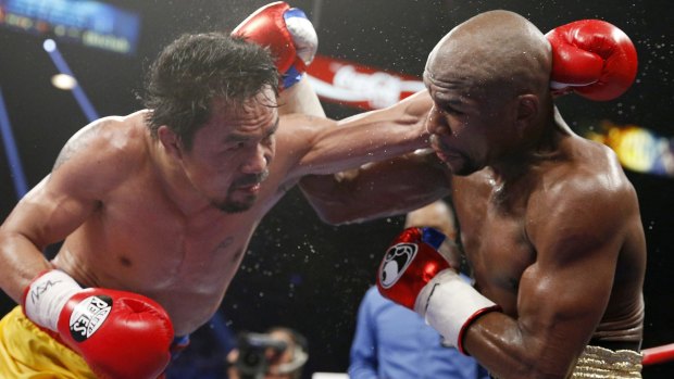 Manny Pacquiao, left, trades blows with Floyd Mayweather Jr. during their welterweight title fight in Las Vegas.