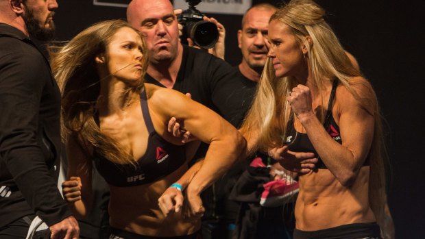 Ronda Rousey (l) confronts Holly Holm (r) during their weigh in at Etihad Stadium.