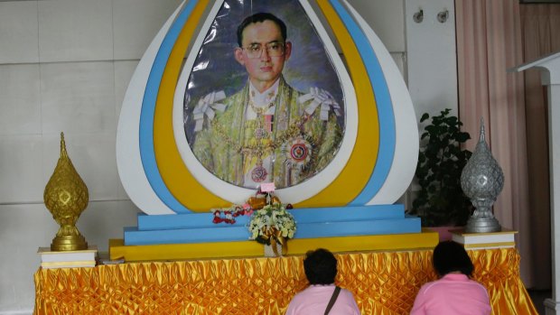 Thais pray in front of a portrait of King Bhumibol Adulyadej in Bangkok.