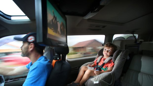 Orlando Moodley, 3, enjoys watching <i>Ice Age</i> on a DVD player while his dad Paul concentrates on driving.