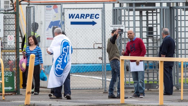 Laid-off Ford workers leaving the Broadmeadows plant at the end of their last shift, some taking selfies. 