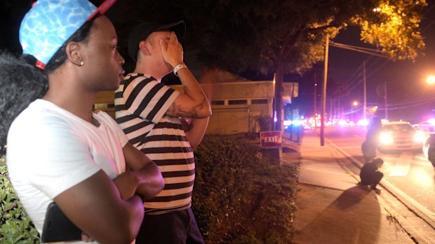 Jermaine Towns, left, and Brandon Shuford wait down the street from the multiple shooting at Pulse nightclub in Orlando.