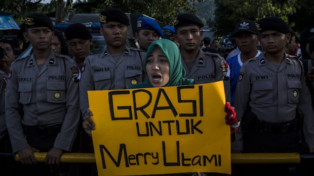 A protester holds a banner during a demonstration against the death penalty of death row prisoner Merry Utami at Wijayapura port, the entrance gate to Nusakambangan prison, on Thursday.