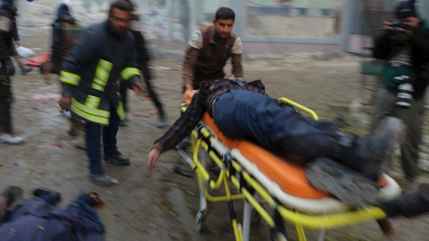 Syrian Civil Defence workers carry a victim on a stretcher after strikes on the Jub al-Quba district in Aleppo where people were killed in the streets.