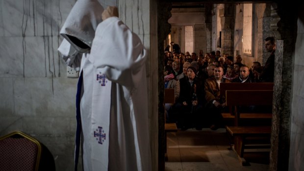 People wait for the start of Christmas Eve Mass at the Mar Shimoni church in Bartella. The predominantly Christian town was liberated from Islamic State during the Mosul offensive.