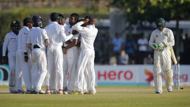 Down and out: Usman Khawaja trudges off as the Sri Lankans celebrate on day two of the second Test.