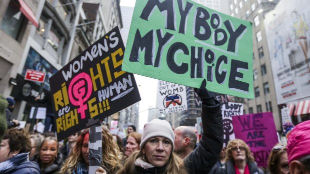 Demonstrators hold signs while marching towards Trump Tower in New York in January, following Trump's inauguration. 