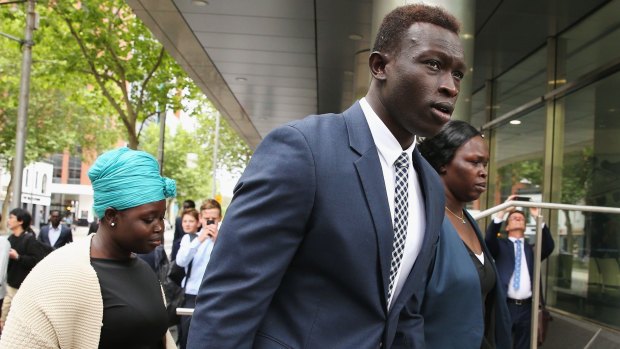 Majak Daw arrives at the Victorian County Court supported by his family.