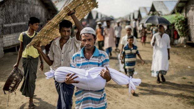 Noor Bashar carries the body of his one-year-old nephew, Mohamad Noor, for burial at a camp for Rohingya in Sittwe earlier this month.