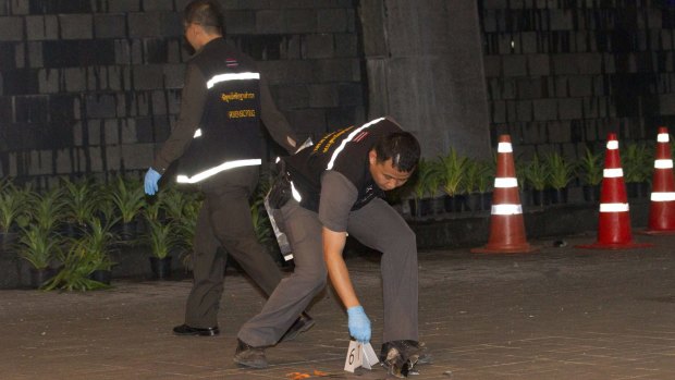 Thai police forensic officers investigate near the front of the Siam Paragon shopping mall, the site of the  blast. 