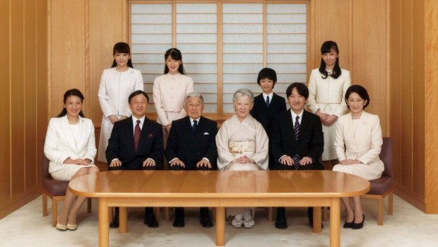 Japanese Emperor Akihito, seated third left, and Empress Michiko, seated fourth left, smile with their family members during a photo session for the New Year at the Imperial Palace in Tokyo. Princess Mako is top left.
