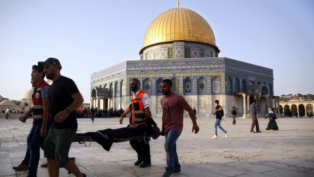Palestinian medics carry a woman on a stretcher near the Dome of the Rock in the al-Aqsa Mosque compound in Jerusalem's Old City.