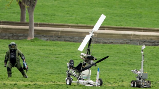 A member of a bomb squad approaches a small helicopter after it landed on the West Lawn of the Capitol on April 15.