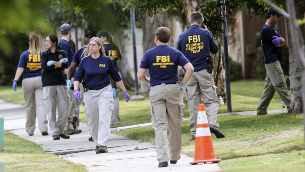 FBI agents search outside a home in connection to the shootings in San Bernardino.