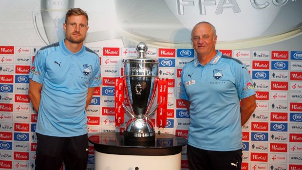 Sydney FC goalkeeper Andrew Redmayne and coach Graham Arnold with the FFA Cup trophy.