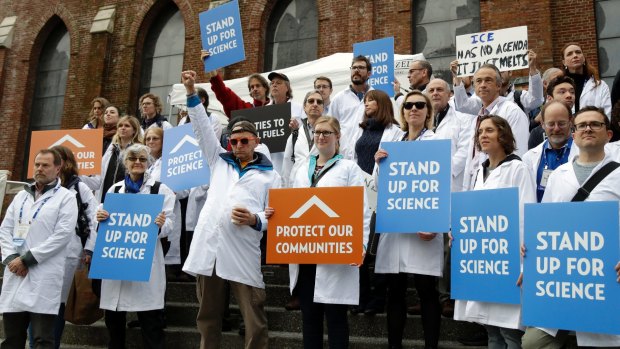 Scientists hold signs during a rally to call attention to what they believe are unwarranted attacks by the incoming Trump administration against scientists advocating for the issue of climate change and its impact. 