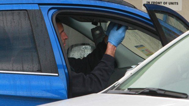 Wodonga police look over a car outside a motel room  Mr El-Zayat and Ms Tannous were staying in.