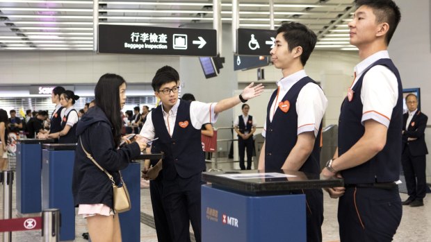 An attendant directs a passenger inside West Kowloon Station.