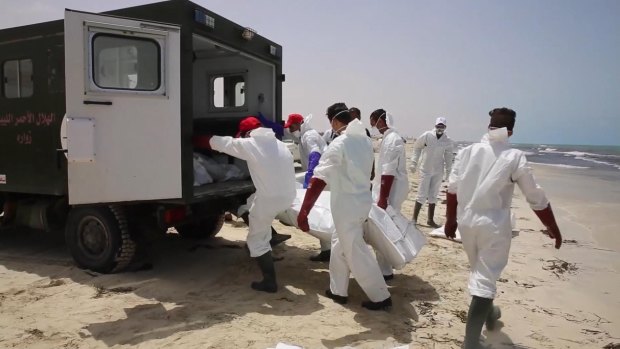 Emergency services remove the body of a victim from the beach near the western city of Zwara, Libya.