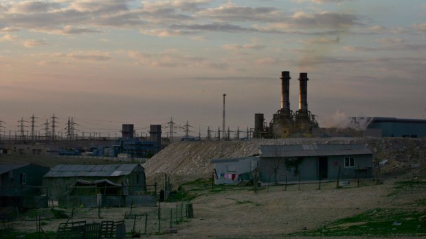 Bedouin homes sit in front of an Israeli power plant at Wadi al-Naam, near Beersheba.  