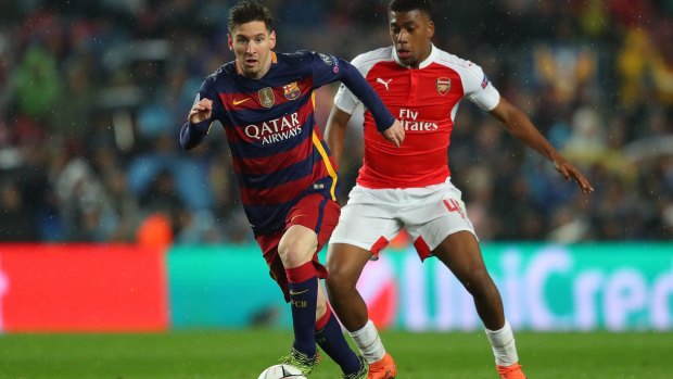 Lionel Messi of Barcelona and Alex Iwobi of Arsenal compete for the ball during the UEFA Champions League, which will be available direct of Foxtel.