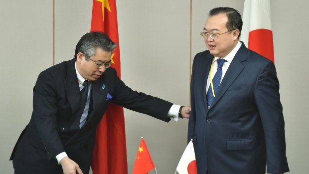 Japan's Foreign Deputy Minister Shinsuke Sugiyama (left) gestures as he welcomes China's Assistant Minister of Foreign Affairs Liu Jianchao (right) prior to the 13th round of Japan-China Security Dialogue at the Foreign Ministry in Tokyo.