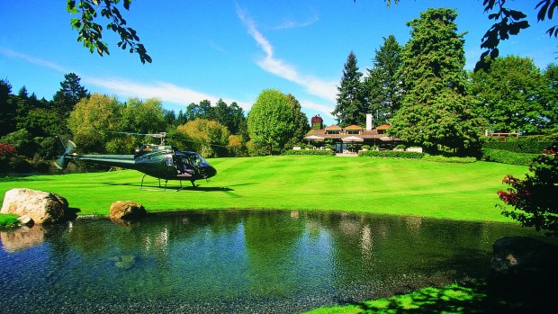 A helicopter lands on the lawn of the lodge. 