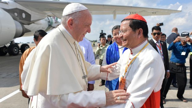 Pope Francis is welcomed by Cardinal Charles Maung Bo on arrival in Yangon.