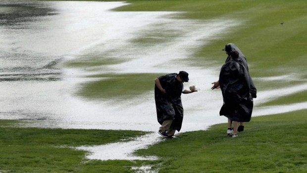 Fans cross the third fairway during a rain delay during the first round of the US Open at Oakmont.