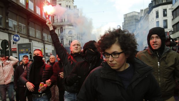 A demonstrator holds a flare at anti-terror demonstrations in Brussels on Sunday.
