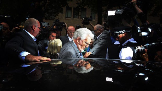 Rolf Harris is surrounded by the media as he leaves Southwark Crown Court during his trial last year. 