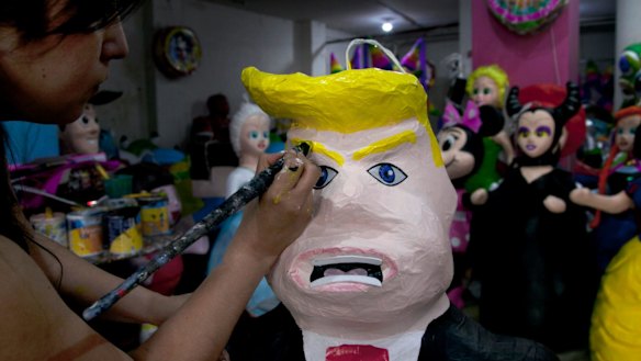 Alicia Lopez Fernandez paints a pinata depicting Donald Trump at her family's store "Pinatas Mena Banbolinos" in Mexico City in 2015.