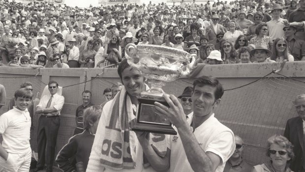 Ken Rosewall holds the cup after beating Mal Anderson, left, at Kooyong.