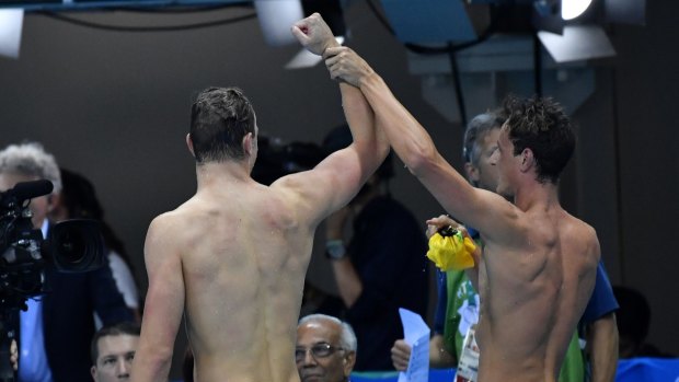 Cameron McEvoy, right, raises Kyle Chalmers' arm in triumph.
