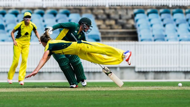Ellyse Perry dives to catch a ball in front of Lizelle Lee