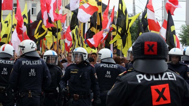 Austrian police face demonstrators during an anti-immigration rally in Vienna.