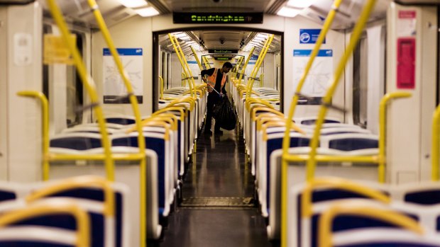 A cleaner clears the mess on a train bound for the city from Sandringham.